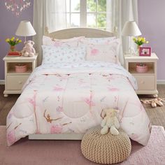 a bedroom with purple walls and white bedding, pink rugs and teddy bears on the floor