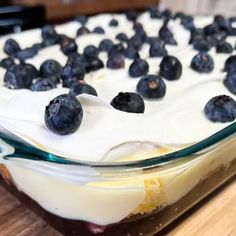 a close up of a cake with blueberries on top and frosting in the middle