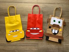 three paper bags with cars on them are sitting on the floor next to each other