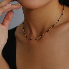 Experience the exquisite beauty of our handcrafted Black Spinel Gold Bean Mini Bead Necklace. Each element is carefully handcrafted to create a refined, elegant look. Add a touch of sophistication to any outfit with this versatile and glamorous necklace. Metal: 18ct Recycled Gold Plated On Brass Gemstone:Black Spinel Pearl: Freshwater Pearl 2.5mm Length: 400-450mm Weight: 5g Elegant Adjustable Beaded Necklaces, Elegant Adjustable Beaded Necklace, Elegant Polished Bead Necklaces, Elegant Faceted Bead Choker Necklace, Elegant Black Beads With Gold Details, Minimalist Gold Beaded Chain, Elegant Black Jewelry With Gold Beads, Elegant Chain Necklace With Tiny Beads, Elegant Beaded Chain Necklaces For Jewelry Making