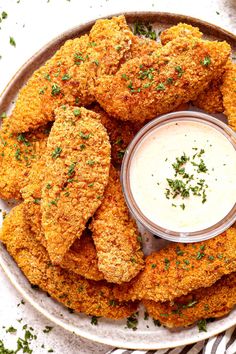 some fried food is on a plate with a small bowl of ranch dressing next to it