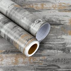 two rolled up papers sitting on top of a wooden table next to an empty roll of paper