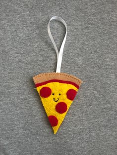 a felt ornament with a slice of pizza hanging from it's side