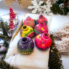 brightly colored vases are sitting on a table next to christmas trees and other decorations