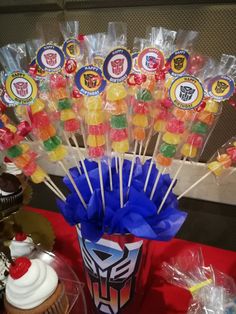 an assortment of lollipops and cupcakes are on display in a vase