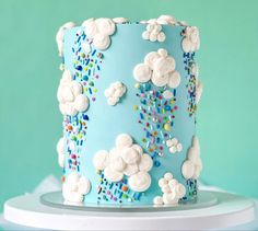 a blue cake with white frosting and sprinkles