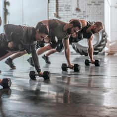 a group of men doing push ups with dumbbells