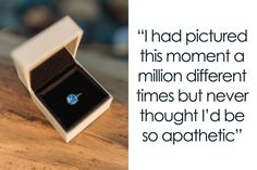 an open box with a ring inside on top of a wooden table next to a quote