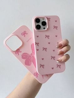 a person holding up a pink phone case with hearts and bows on the back in their hand