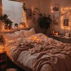 an unmade bed with candles and pictures on the wall