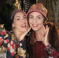 two women sitting at a table posing for the camera