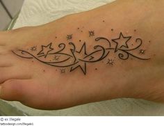 a woman's foot with stars on it and the word love written in cursive writing