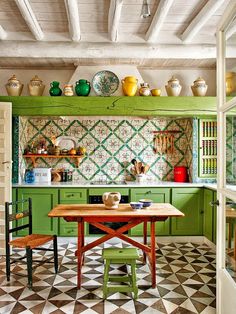 a kitchen with green cabinets and an island in the middle, surrounded by black and white checkered flooring