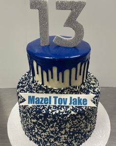 a blue and white cake with the number thirteen on top