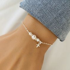 Dainty Cross Bracelet, Baptism Gift, Baby Christening Bracelet, First Communion Gift, Confirmation Gift, White Pearl Jewellery, Gift for Her ❤ Available in silver and gold. ❤ Specification . Chain and components are 925 Sterling Silver or 14K Gold Filled . Cross size 4.5 x 8.5mm . Pearls are Swarovski with size 4mm and 6mm . Length includes pearls, jump ring and clasp . Comes in our signature pouch ready for gift giving ♥ More collections from StampedEve: https://www.etsy.com/au/shop/StampedEve?ref=l2-shopheader-name IMPORTANT: Usually jewellery in the pictures looks bigger than in reality. Please consider all given dimension and compare them to the ruler before ordering. ❤ About My Jewellery Each piece of jewellery of my shop is handmade and therefore unique - no two items going to look e Adjustable Cross Bracelets For Wedding, Adjustable Cross Bracelets For Weddings, Elegant Cross Rosary Bracelet For Wedding, Elegant Cross-shaped Rosary Bracelet For Wedding, Elegant Silver Rosary Bracelet For Baptism, Elegant White Rosary Bracelet For Birthday, Elegant Bracelet Jewelry For Baptism, Dainty White Jewelry For Baptism, White Pearl Jewelry