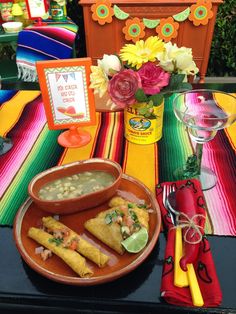 mexican food is served on a table with flowers and other decorations in the background at a birthday party