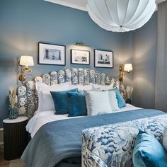 a blue and white bedroom with pictures on the wall