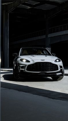 a white sports car parked in an empty parking garage with its hood up and lights on