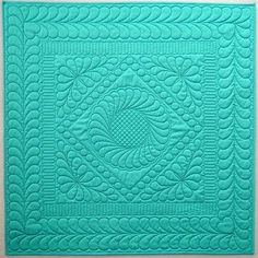 a blue quilted placemat with an intricate design on it