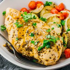 a white plate topped with chicken and vegetables