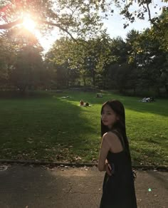 a woman standing in the middle of a park