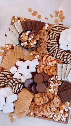 an assortment of cookies, marshmallows, and chocolate on a platter