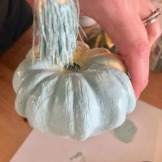 a person is painting a pumpkin with blue paint