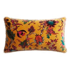 a yellow and red floral pillow on a white background with an orange fringe trimming