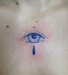 a close up of a person's chest with an evil eye tattoo on it