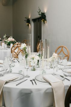 the table is set with white linens and place settings for two people to sit at