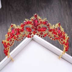 a red and gold tiara on top of a white box