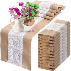 a table topped with lots of burlap and lace covered placemats next to a vase filled with flowers