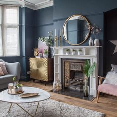 a living room filled with furniture and a fire place in front of a mirror on the wall