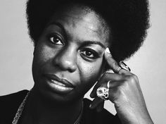 a black and white photo of a woman talking on a cell phone with an afro hairdo