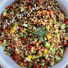 a white bowl filled with lots of food on top of a wooden table and the words what's salad written above it