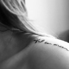 the back of a woman's shoulder with words written on it