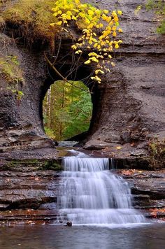 a small waterfall is coming out of a cave