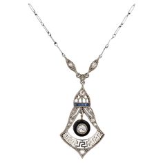 This unique antique diamond filigree necklace carries the heritage of two eras. The late Edwardian period gives way to the Art Deco as exemplified by the Greek key openwork design. Centered by an old mine cut diamond swinging freely in a black onyx donut and embellished with twinkling rose cut diamonds. This circa 1913 relic has a distinctive shape with great attention to detail . Condition: Good; consistent with age & use (minor abrading of sapphires & onyx) Era: Late Edwardian Early Art Deco Y Luxury Filigree Art Deco Necklace, Filigree Pendant Necklace, Old Mine Cut Diamond, Filigree Necklaces, French Cut, Filigree Pendant, Unique Antiques, Art Deco Diamond, Antique Diamond