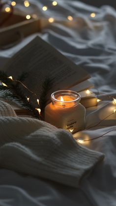 a candle and some books on a bed