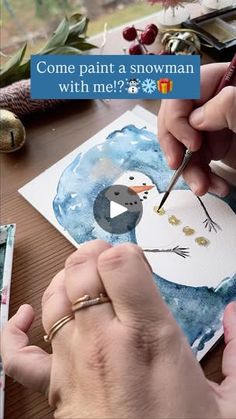 someone is painting a snowman on paper with watercolors and crayons