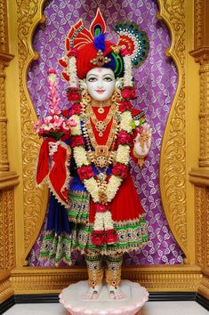 an idol is displayed in front of a purple wall