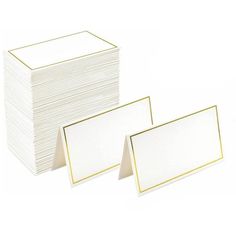 two stacks of white cards with gold trim