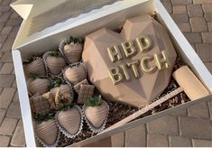 a box filled with chocolate covered strawberries on top of a brick floor next to a sidewalk