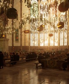 people are sitting on benches in the middle of a room with chandeliers hanging from the ceiling