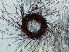 a wreath made out of twigs sitting on top of a wooden surface with the words the naturals written below it