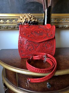 a red purse sitting on top of a wooden table