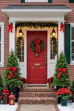 a red front door decorated with christmas wreaths