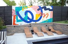 some wooden lounge chairs sitting in front of a wall