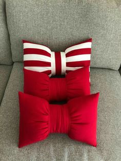 two red and white pillows sitting on top of a couch