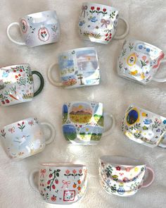 many different cups and saucers on a white surface